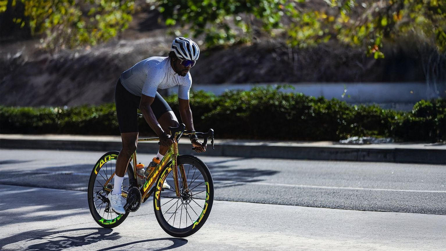 a man riding a bike down a street in the sun